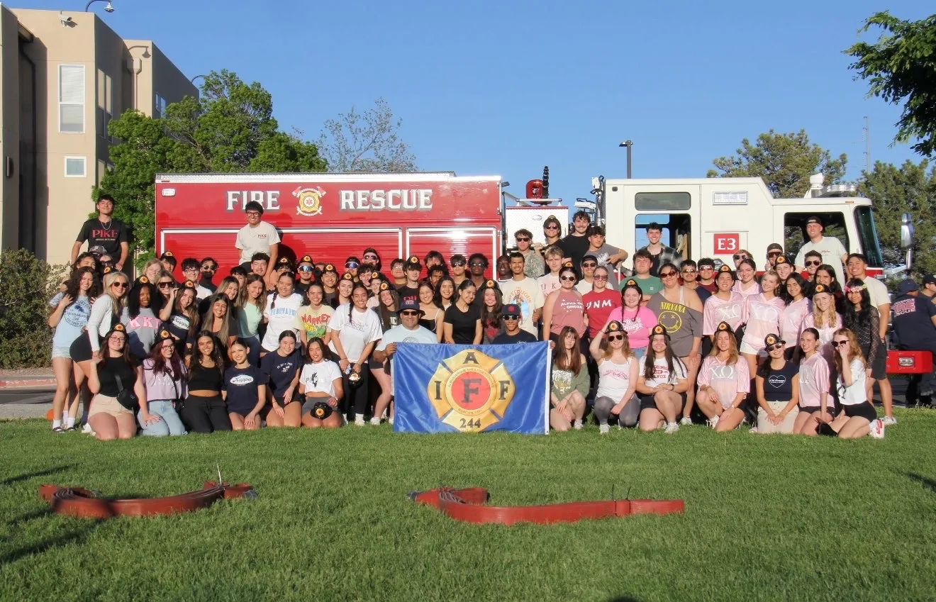 A LARGE GROUP OF STUDENTS AND BROTHERS WITH A FIRE TRUCK.